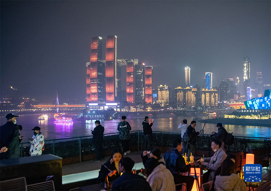 游客在重庆弹子石老街里的一家酒吧品酒赏夜景(12月8日摄.