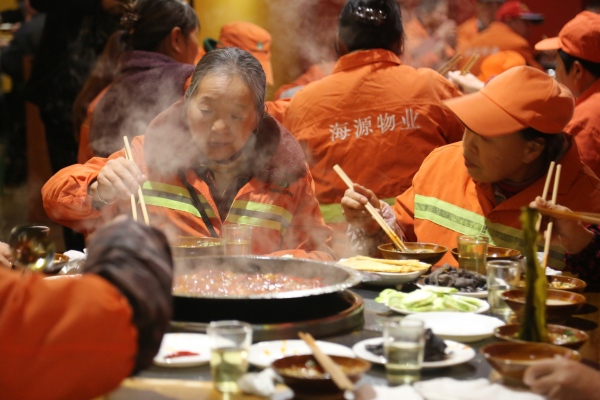 环卫工人与保洁人员一起免费享用火锅大餐。杨孝永摄